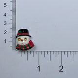 Description: Snowman head button with tiny goggly eyes, wearing a green and red scarf and a black top hat on a ruler background. 
Material: Polyester
Type: Shank
Size: 1 inch (25.5 mm)